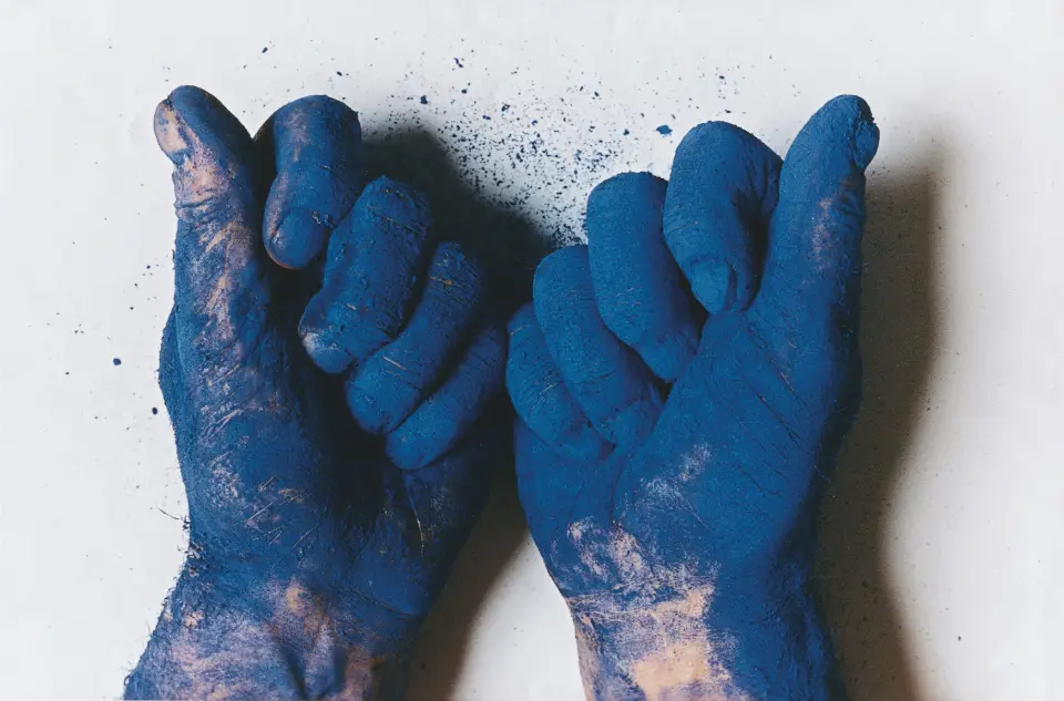 Zwei Hände voller blauer Farbpigmente