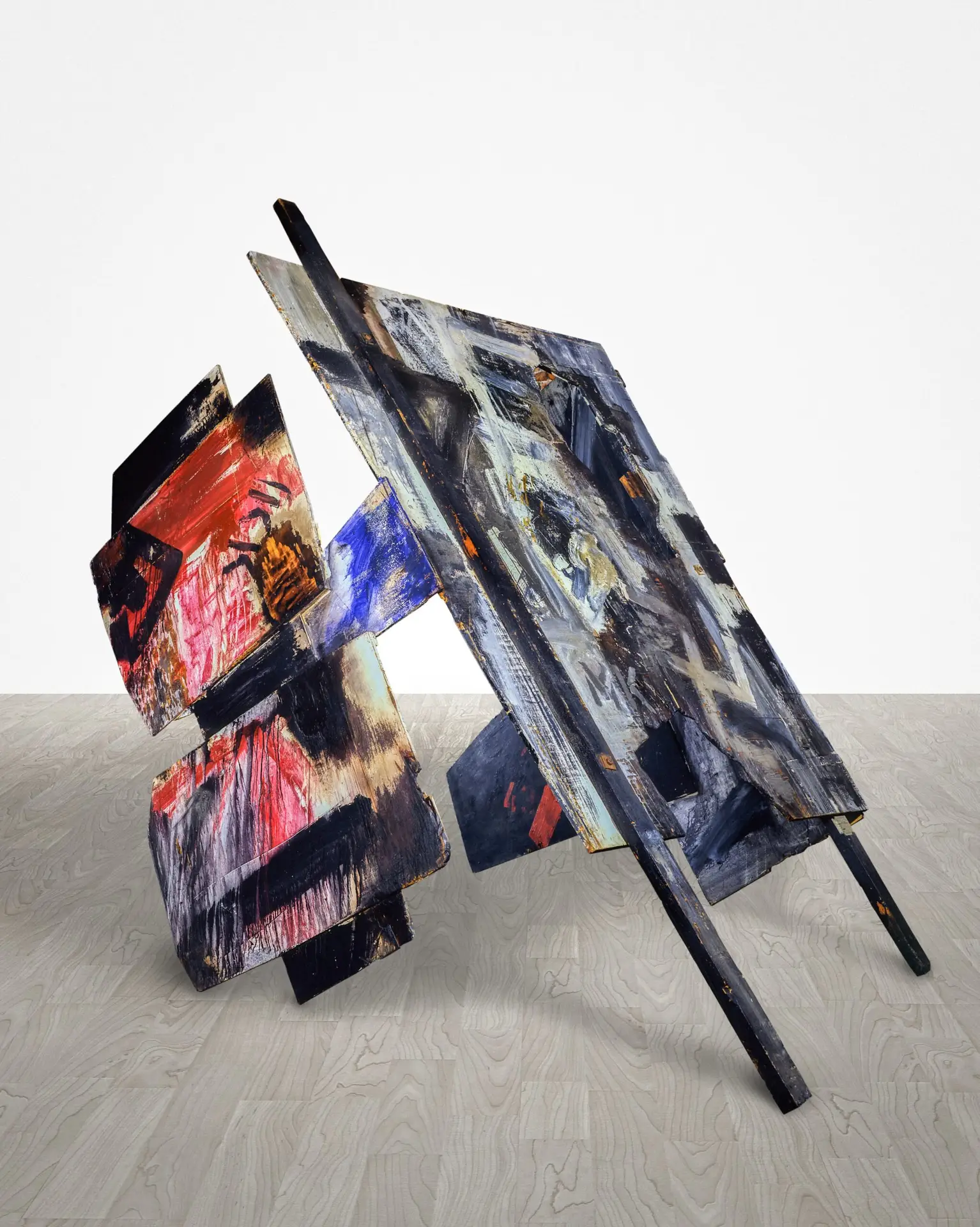 Skulptur von Emilio Vedova aus bemalten, schräg angeordneten Holzplatten mit abstrakten Formen in Rot, Blau, Schwarz und Grau auf hellem Boden